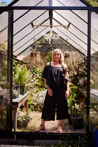 Voyager jumpsuit in black stretch fabric with elasticated cape and blanket stitch | Libertine The Label