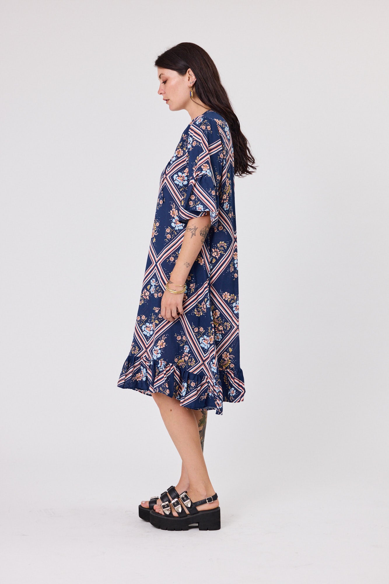 Woman wearing a navy floral dress on a white background