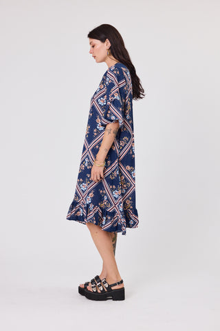 Woman wearing a navy floral dress on a white background