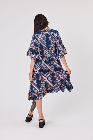 Woman wearing a navy floral dress on a white background