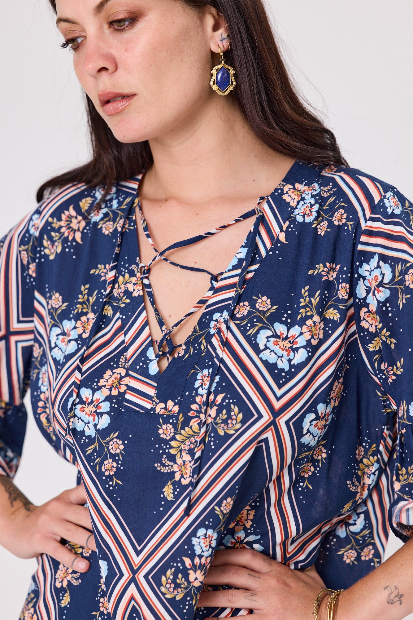 Woman wearing a blue floral blouse with a white background