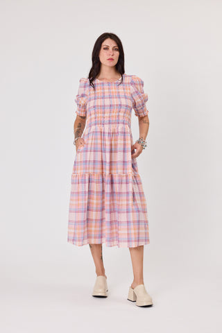 Woman wearing a plaid dress on a white background