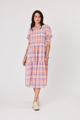 Woman wearing a plaid dress on a white background