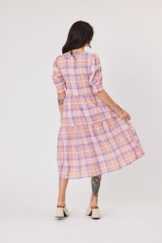 Woman wearing a plaid dress on a white background