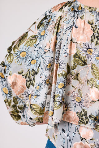 Floral patterned garment with pink flowers and green leaves on a light background