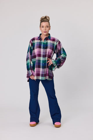 Woman wearing a plaid shirt and blue denim knit leggings