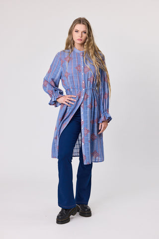 Oasis Heritage Stitch Dress featuring a blue patterned fabric and stylish long sleeves, worn with blue pants.