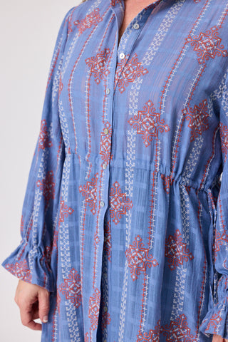 Close-up of the Oasis Heritage Stitch Dress showcasing detailed embroidery on a blue fabric.