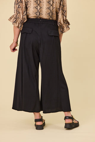 Voyager wide-leg pants in black stretch fabric with blanket stitch hem | Libertine The Label