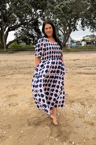 Bianca, NZ size 16, walking barefoot on the beach in the Sienna Dress in indigo shibori, our size L | Libertine The Label