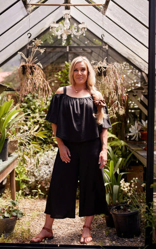 Voyager jumpsuit in black stretch fabric with elasticated cape and blanket stitch | Libertine The Label