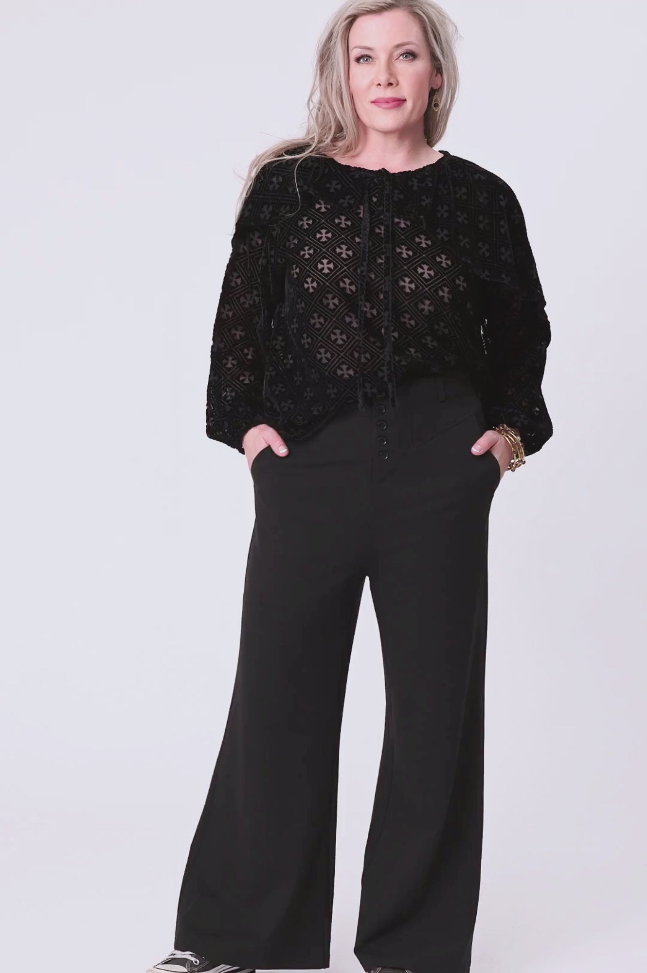 woman wearing black burn out velvet blouse and black pants