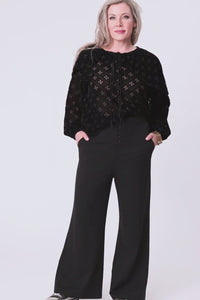 woman wearing black burn out velvet blouse and black pants