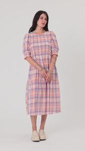 woman wearing melon plaid midi dress