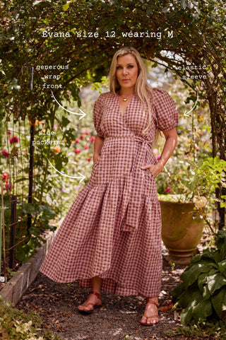 A woman modelling a marshmallow and choc latte seersucker cotton wrap maxi dress with three-quarter frill-cuff sleeves and a deep hem frill, tied at the waist.