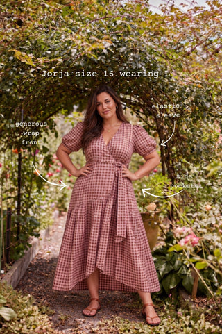 A woman modelling the same marshmallow and choc latte seersucker cotton wrap maxi dress, showing the adjustable tie waist and generous wrap overlap through the bust.